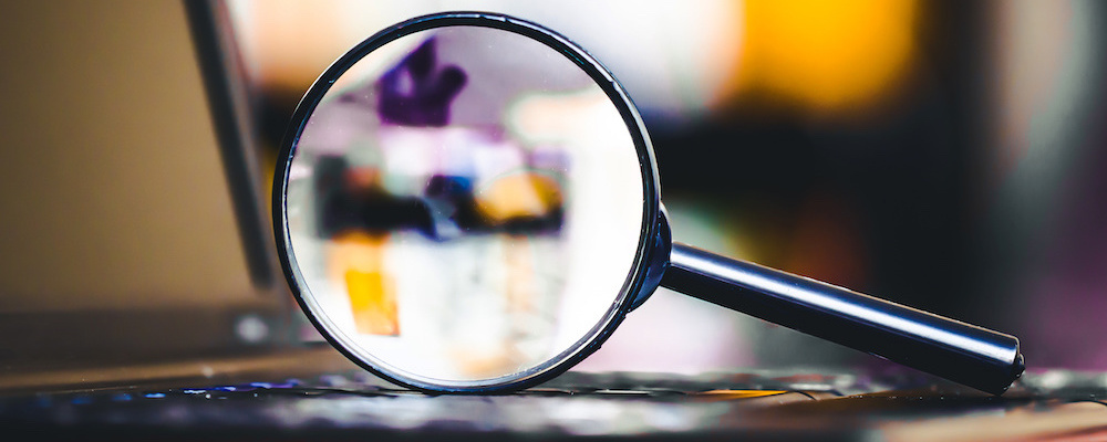 A magnifying glassed focused on a laptop computer
