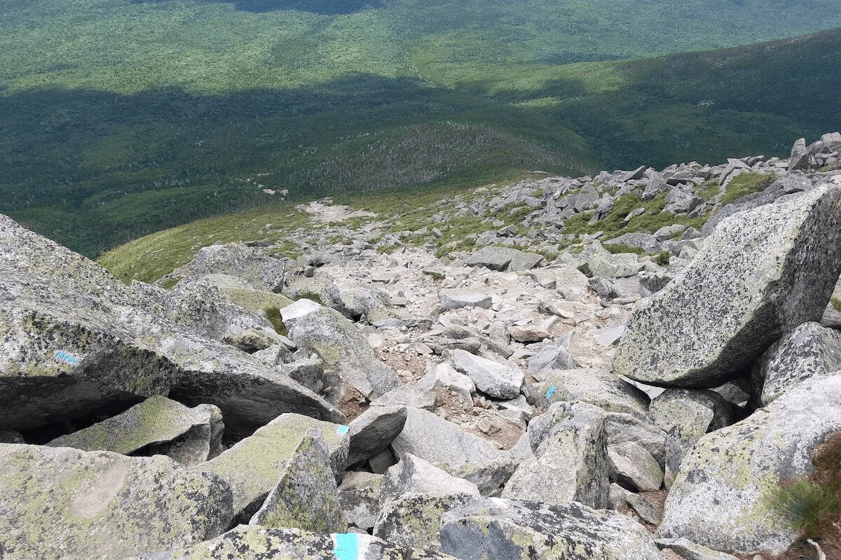 View from the top of Abol trail on the bare side of Mount Katahdin; the forest at the bottom of the mountain is plainly visible a mile below at the base of the steep boulder-strewn trail