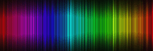 A waveform of the visible light spectrum from violet to red atop a black background