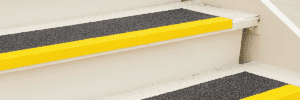 A set of stairs with textured horizontal surfaces and bright yellow lines on their edges