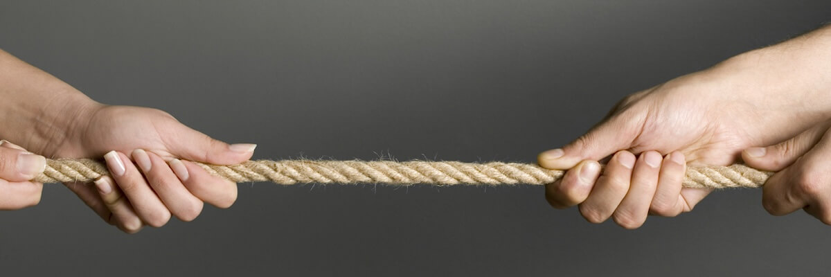 Two sets of hands pulling in opposite directions on a taut rope as if playing tug-of-war