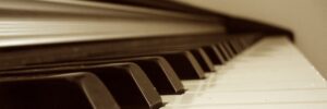 Closeup view from the bottom end of a piano keyboard in sepia tone