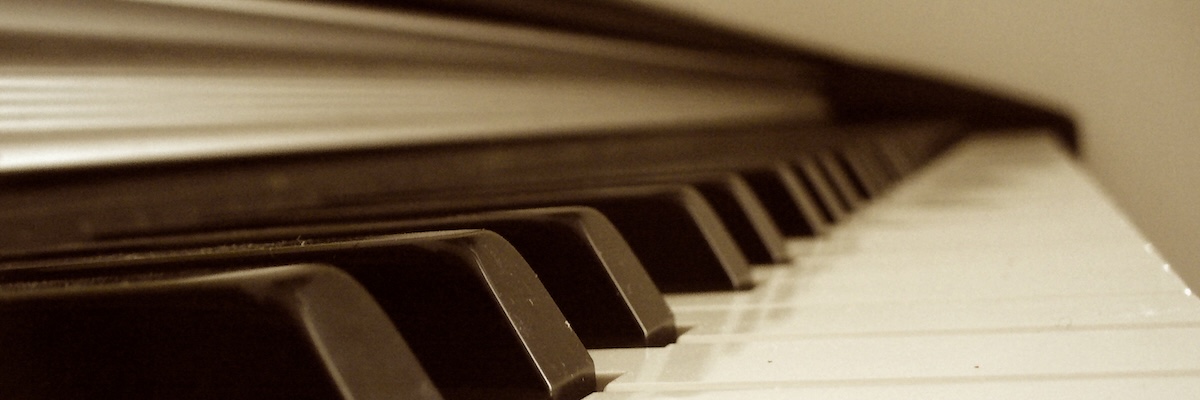 Closeup view from the bottom end of a piano keyboard in sepia tone