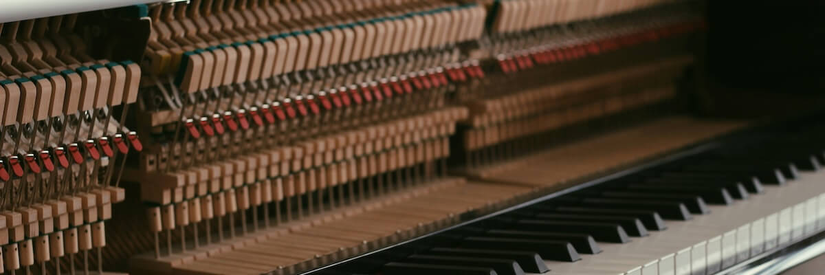 The hammers beneath an upright piano cover above the instrument's keys